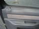 1981 Ford Bronco - Close-up of a vehicle's interior door panel, showing gray plastic and fabric trim details.