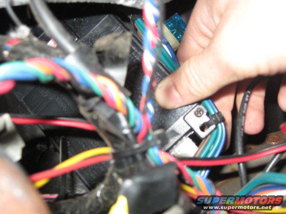 Hand connecting wires to a fuse in a complex wiring harness