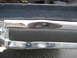 1981 Ford Bronco - Close-up of a vehicle's front bumper, revealing chrome and black rubber details.