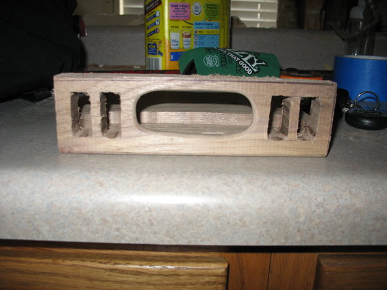 Wooden overhead console part with rectangular cutouts and an oval opening