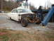 1963 Ford Galaxie - A white 1963 Ford Galaxie chassis sits on a gravel lot with its front end dismantled.
