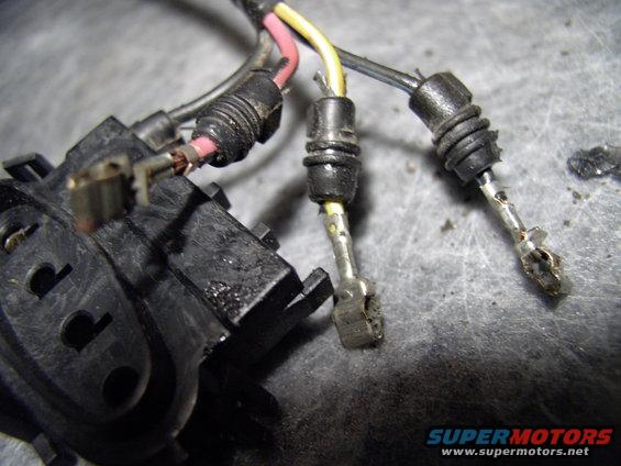 One of the terminals plugged into the new connector. Note the rubber barbs that keep it weather proof. On the loose black wire note the tang on the metal clip. That clicks into the connector to hold them in.