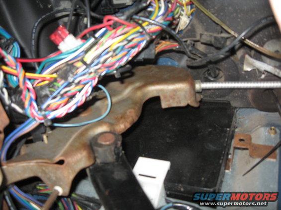 Close-up of a vehicle's interior wiring harness and metal bracket