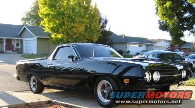 Black 1970 Ford Ranchero with a hood scoop, parked in a driveway