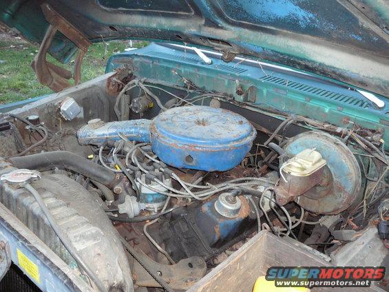 Engine bay with blue air cleaner and various hoses and wires