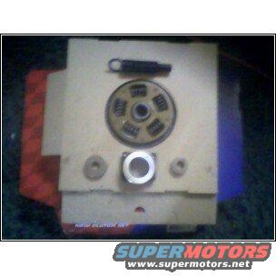Clutch assembly with springs and pressure plate on a beige surface, red and blue fabric visible