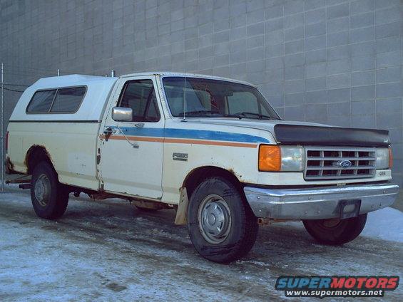 White 1990 Ford F-250 pickup truck with camper shell, 3q front view