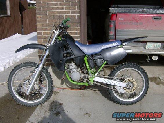 Dirt bike parked next to a red Dodge pickup truck