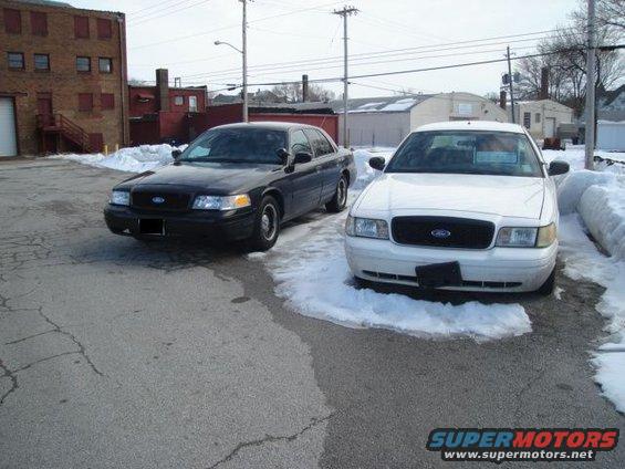 Two Ford Crown Victorias parked outside with snow on the ground