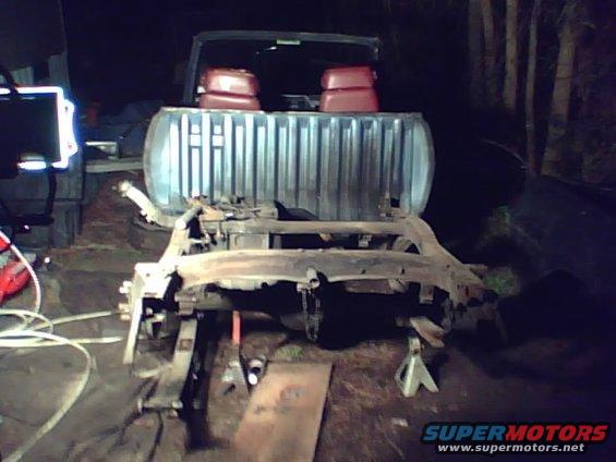 Truck chassis disassembled and supported by jack stands in a workshop