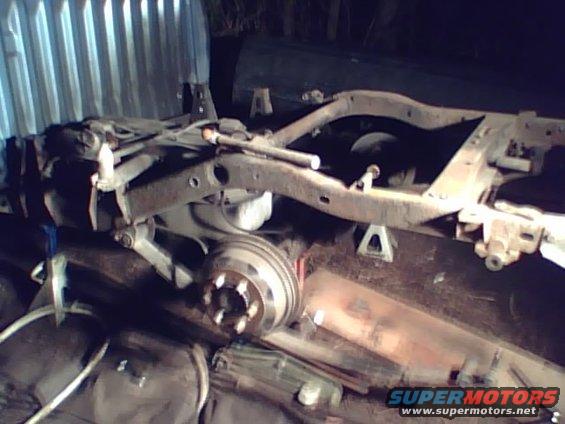 truck frame on jack stands, showing suspension and brake drum
