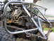 1995 Ford Bronco - The chassis and engine of a custom off-road vehicle are visible, modified with a roll cage.