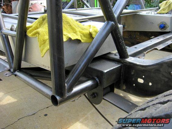 Roll cage tubing welded to a metal chassis with a yellow towel draped over a fuel tank