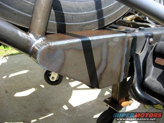 Custom roll cage fabrication with visible welds and a spare tire
