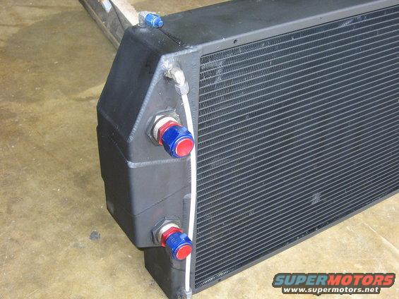 Close-up of a black radiator with blue and red fittings
