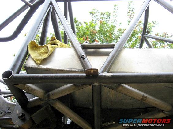 Custom roll cage surrounding a fuel tank with a yellow rag