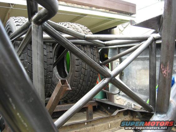 Roll cage structure with spare tires visible behind it