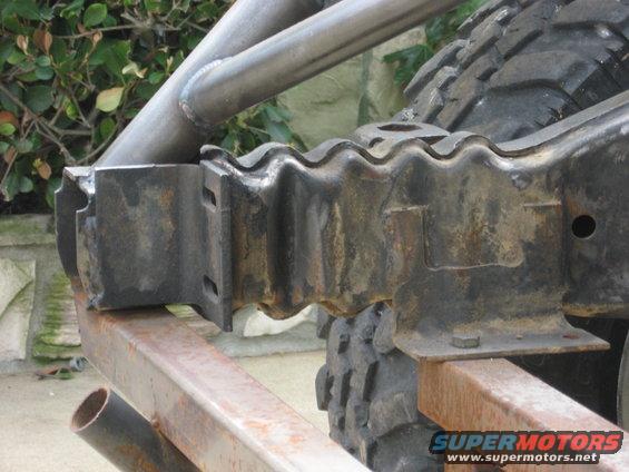 Close-up of a heavy-duty suspension component with a large tire visible behind it