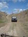 2008 International School Bus - Two Jeeps navigate a dusty trail under a partly cloudy sky.