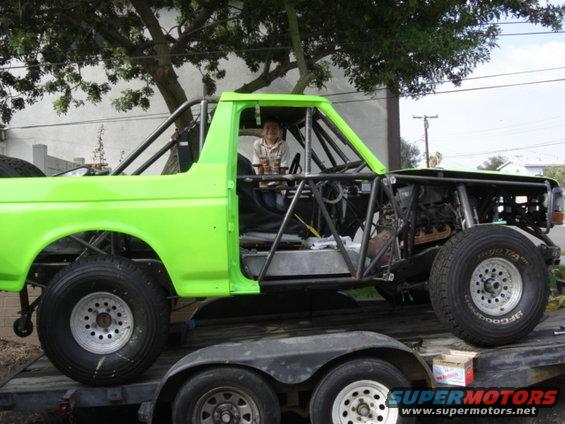 Lime green 1995 Ford Bronco race truck with exposed engine and roll cage