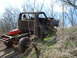 2008 International School Bus - A heavily weathered truck chassis, missing its body, navigates a dirt path.