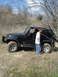 2008 International School Bus - A black Jeep Wrangler Rubicon is parked off-road with a person standing by the driver's side door.
