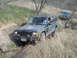 2008 International School Bus - Two Jeep Cherokees navigate a rough, grassy trail with dry brush and trees.
