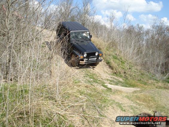 Black Jeep Wrangler driving down a dirt embankment