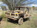 2008 International School Bus - This weathered pickup truck sits abandoned in a grassy field, its engine exposed and body showing significant wear.