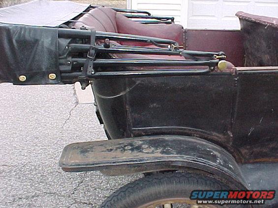 Rear passenger side of a 1913 Ford Model T touring car with burgundy interior and black canvas top