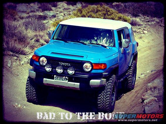 Blue 2007 Toyota FJ Cruiser with white roof and aftermarket lights on a dirt road