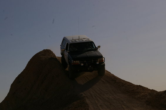 Black 1992 Ford Bronco climbing a dirt hill, text "FSB" on roof