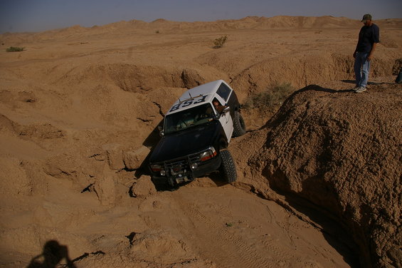 Black and white off-road vehicle with "ESB" text on the side, navigating a steep sandy incline
