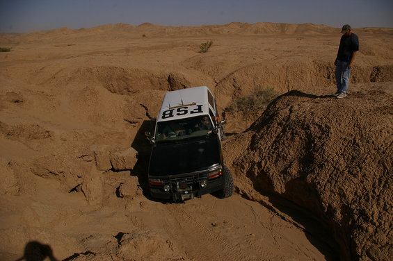 Black and white SUV with FSB on roof stuck in sandy terrain