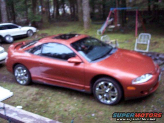 Red 1995 Mitsubishi Eclipse coupe with sunroof, parked in a yard