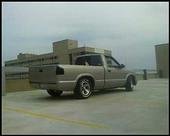 Gold pickup truck parked on a rooftop, overcast sky