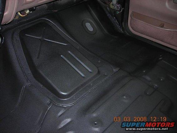 vehicle floor pan with some raised sections and a door panel visible