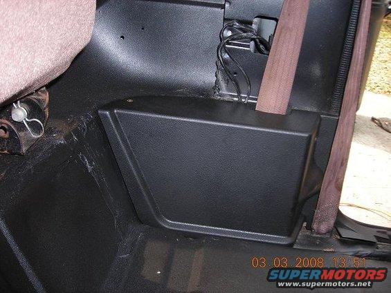 Black plastic trim piece and seatbelt in a vehicle interior