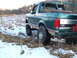 1996 Ford Bronco - Rear view of a lifted green Ford Bronco with off-road tires in a snowy, grassy field.