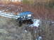 1996 Ford Bronco - A dark green 1996 Ford Bronco navigates a challenging off-road course with snow and dry grass.