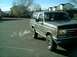 1989 Ford Bronco - A gray Ford Bronco is parked on an asphalt surface, with a plume of exhaust smoke visible.