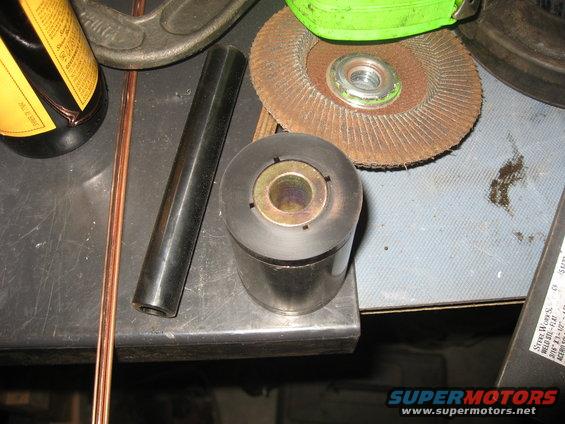 Close-up of a metal bushing, grinding disc, and bottle