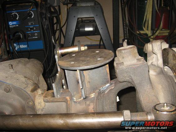 Custom suspension part with welded metal brackets and a circular plate