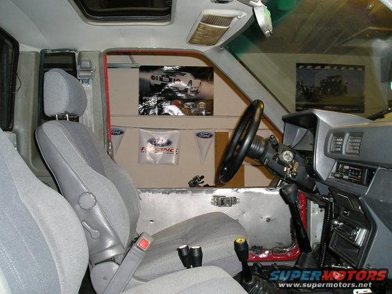 Interior of a truck with grey seats, a black steering wheel, and a dashboard with a radio