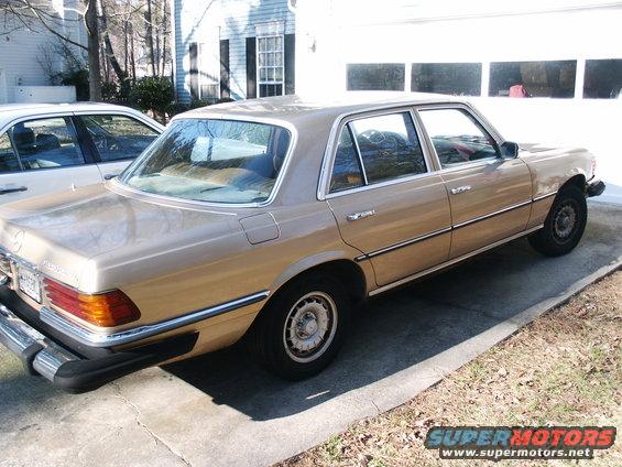 Tan Mercedes-Benz sedan parked on driveway, rear quarter view