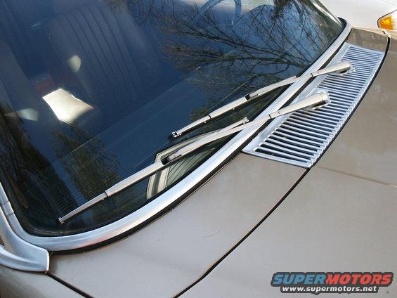 Windshield wipers and chrome grille on a tan car