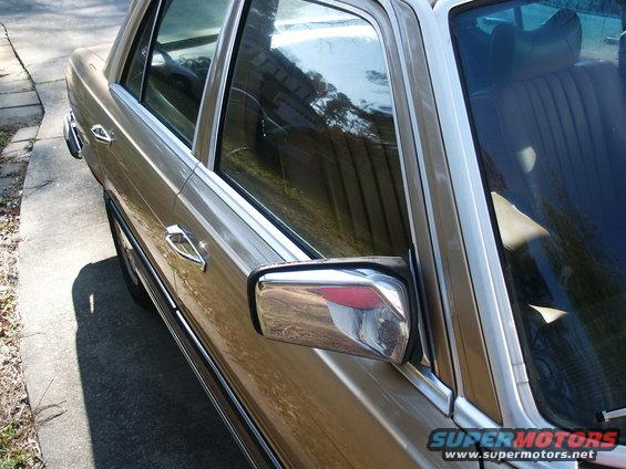 Side view of a gold 1980 Mercedes-Benz S-Class sedan, showing door handle and side mirror