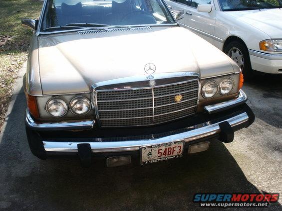 Gold Mercedes sedan front end, another white car behind it