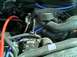 1989 Ford Bronco - Close-up view of engine bay components including hoses and alternator, with a Supermotors.net logo.