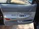 2003 Ford Crown Victoria - The interior door panel of a 2003 Ford Crown Victoria features gray trim and power window controls.